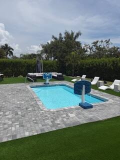 Pool with lounge chairs and turf