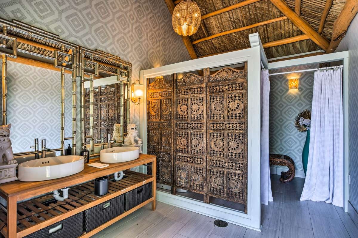 Outdoor tiki-style bathroom with carved doors