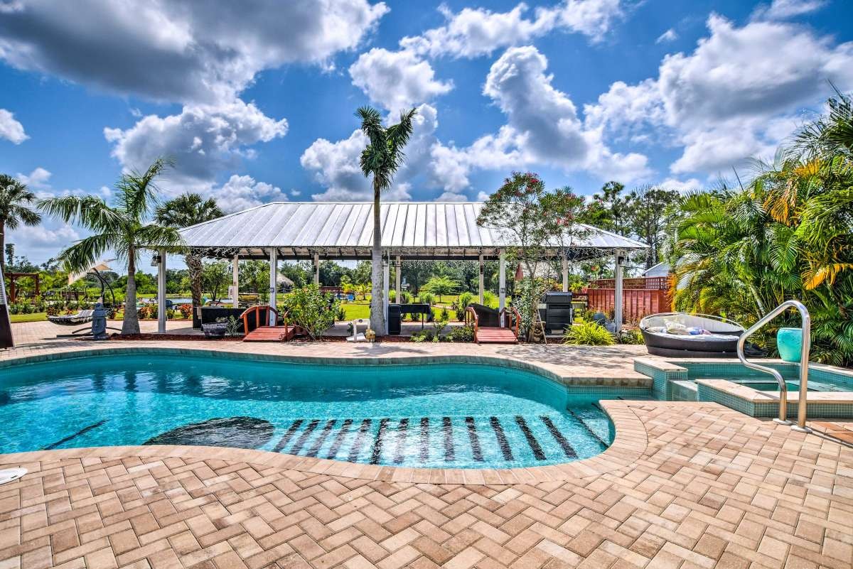 Guitar-shaped pool with pergola pavilion and hot tub